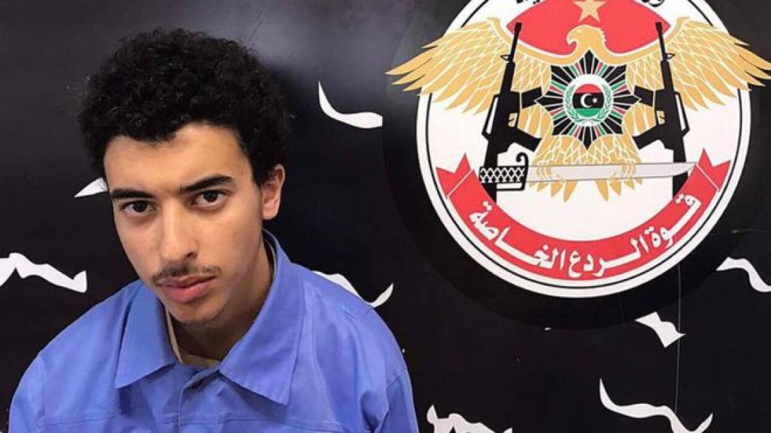 Hashem Abedi, brother of the Manchester Arena suicide bomber, in a blue shirt with a crest featuring an eagle and weapons in the background.