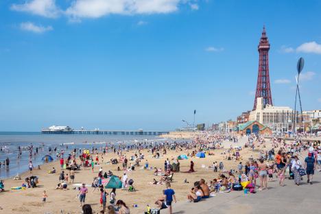 Crowded Blackpool beach with the Blackpool Tower in the background.