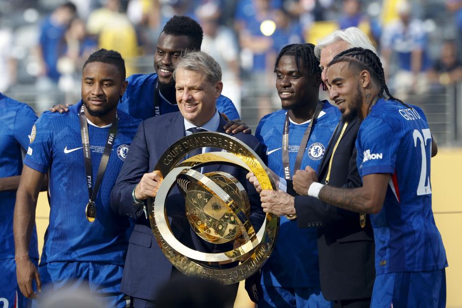 Todd Boehly and Chelsea FC players holding the FIFA Club World Cup trophy.