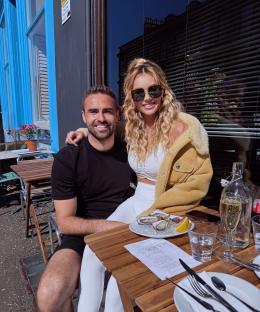 Couple sitting at an outdoor table enjoying oysters and champagne.