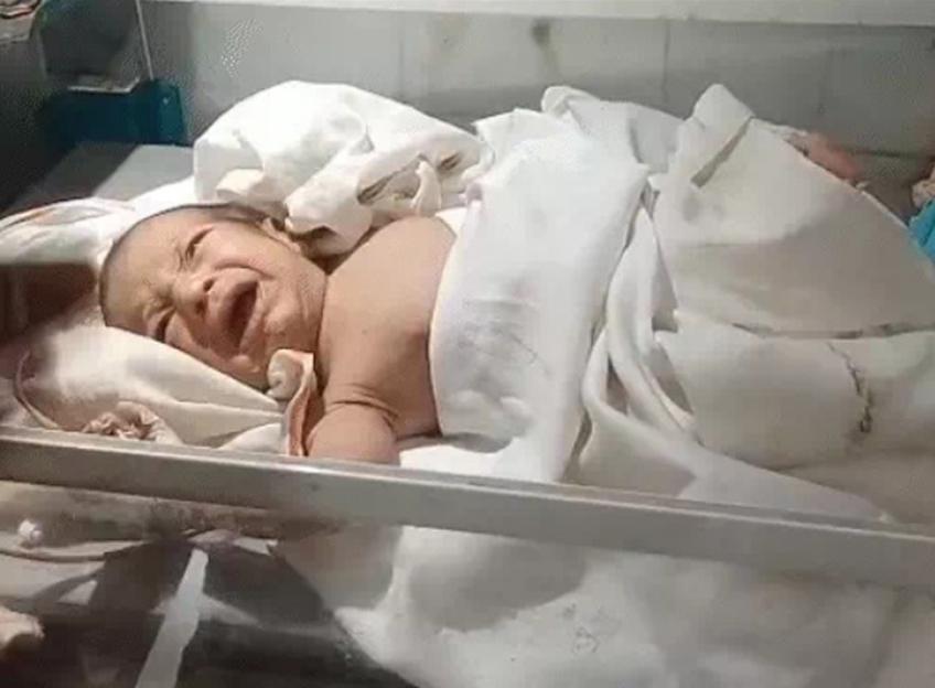 Crying abandoned baby found with a stone in its mouth.