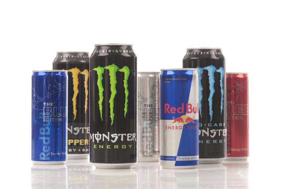 Several cans of Red Bull and Monster energy drinks.