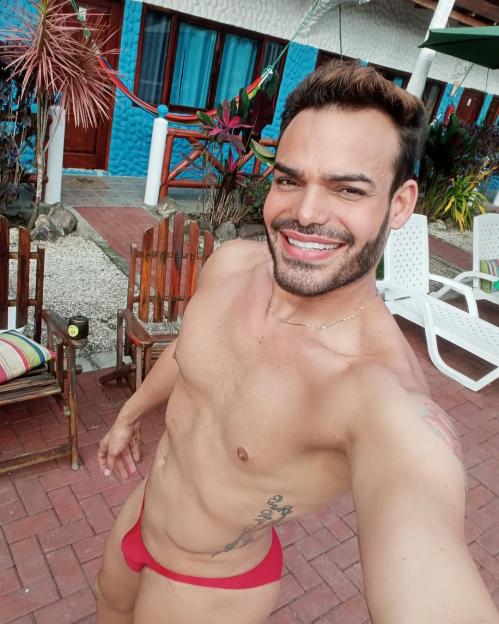 Emilio Sueños, a TV presenter, smiling while wearing a red speedo.
