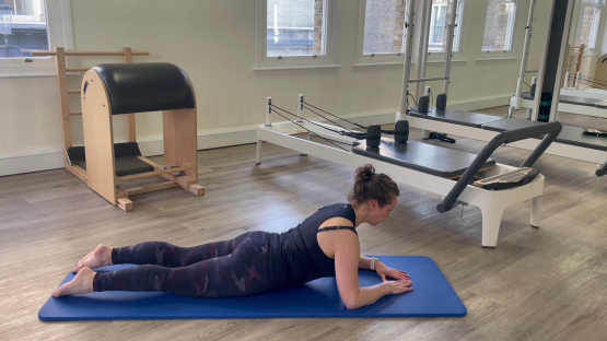 Woman performing a Pilates exercise on a mat.