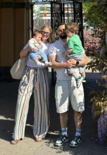 Family photo in front of a wisteria bush.