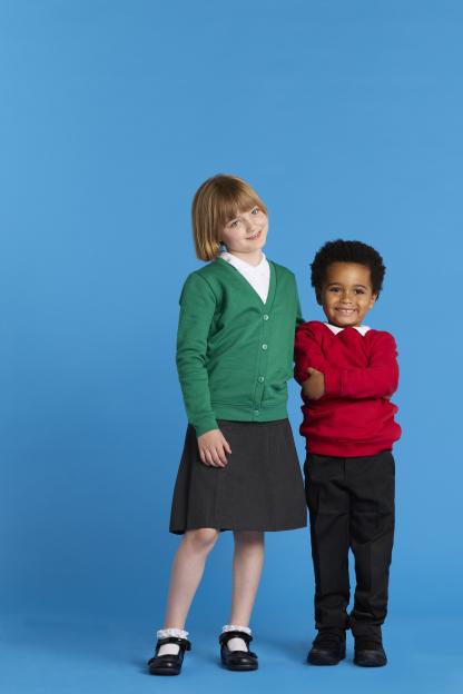 Two children in school uniforms stand together against a blue background.