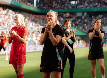 Georgia Stanway of Bayern Munich clapping with teammates after a soccer game.