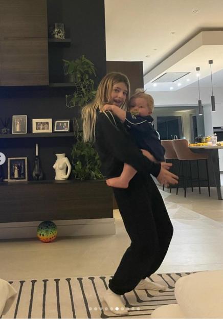 Katherine Ryan holding her baby Fenna in a living room.