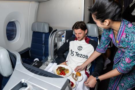 Mason Mount of Manchester United being served a meal on a plane.