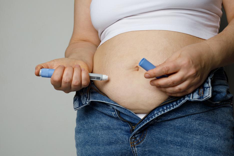 Woman injecting Semaglutide Ozempic into her abdomen to control blood sugar levels.