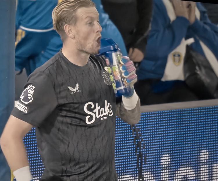 Goalkeeper drinking from a water bottle.