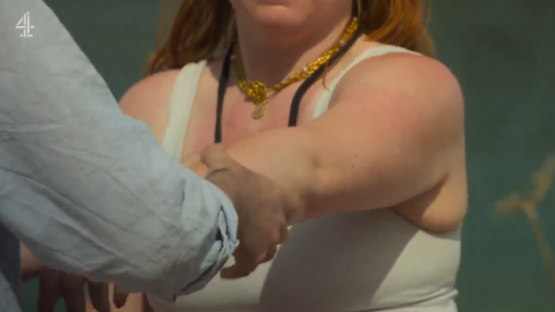 Charlotte and Jason holding hands on a beach.