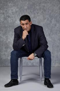 Portrait of Steven Gillen, ex-gangster, sitting on a clear chair.