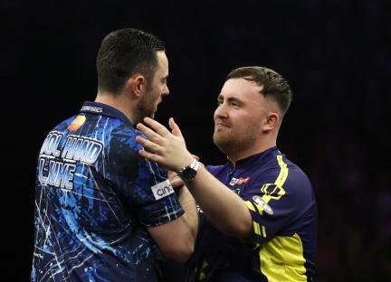 Luke Humphries and Luke Littler embracing after a darts match.