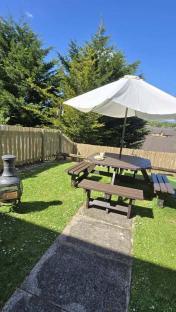 Garden patio with picnic table and umbrella.