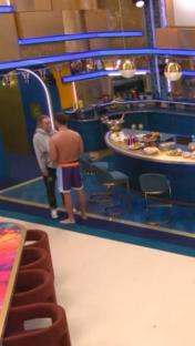 Chris Hughes and JoJo Siwa in conversation in a brightly lit room.