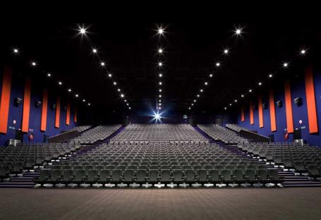 Large movie theater auditorium with many empty seats.