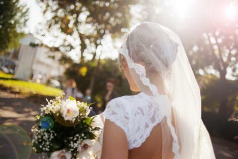 Bride from behind holding a bouquet.