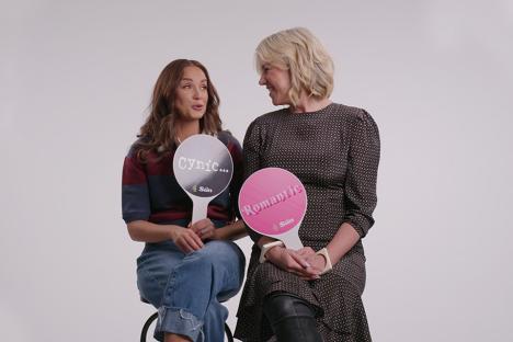 Two women holding signs that say 