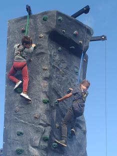 Two boys climbing a rock wall.