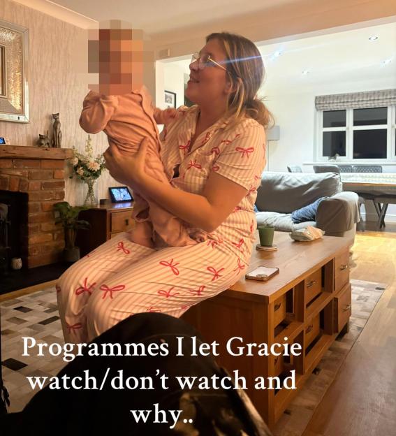 Mother in pajamas holding her baby in pajamas, sitting on a coffee table.