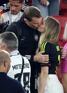 Manuel Neuer and his wife kissing after a soccer match.