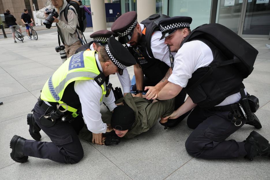 Police officers arresting a protester.