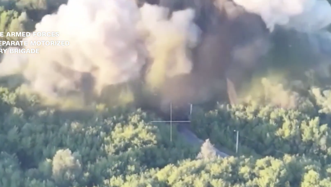 Aerial view of an explosion in a wooded area.