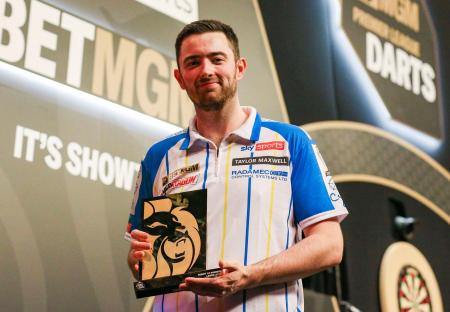 Luke Humphries holding a Premier League Darts trophy.