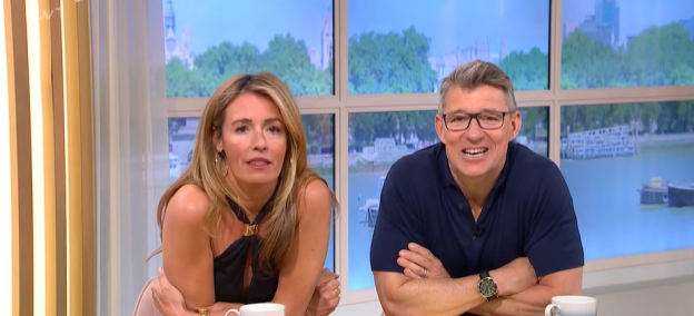 Screenshot of two television presenters sitting at a table.