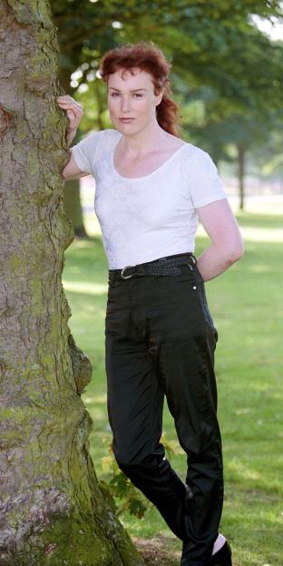Lynsay Watson, a transsexual former student nurse, standing outdoors near a tree.