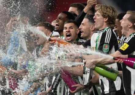 Newcastle United players celebrating a victory with champagne.