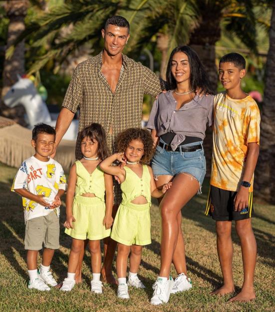 Cristiano Ronaldo, Georgina Rodriguez, and their children posing for a family photo.