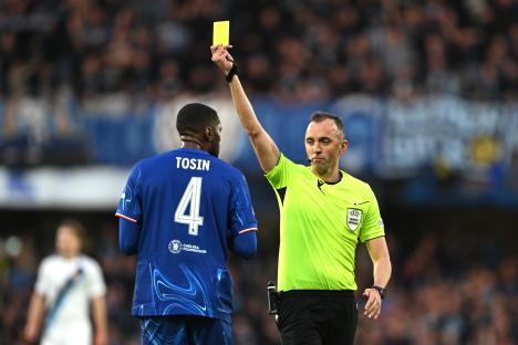 Referee showing a yellow card to a Chelsea player.