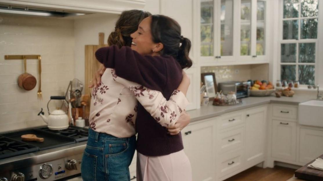 Meghan Markle and another woman embracing in a kitchen.