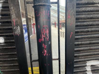 Closed shopping center with graffiti on a gate.