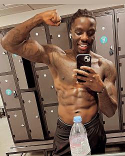 Man flexing in gym locker room.