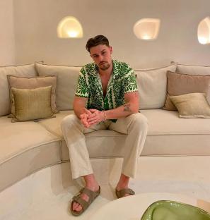 Andrew Le Page sitting on a beige couch.