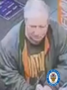 Surveillance image of a man wearing a gray jacket and orange scarf.