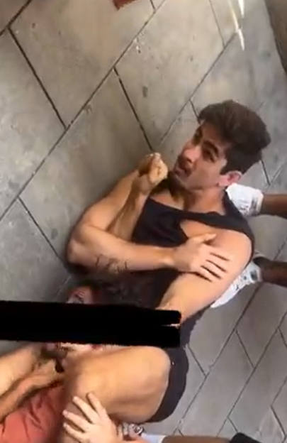 Man being restrained on the ground.