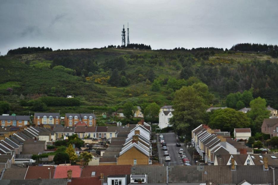 Houses near a hill with communication towers.