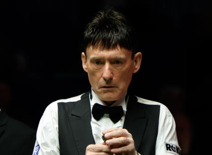Jimmy White chalking his cue at a snooker match.