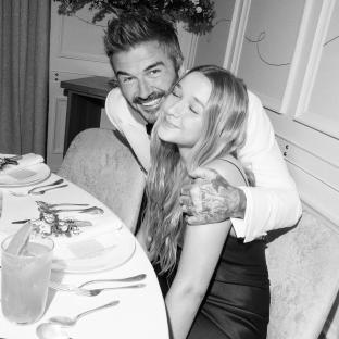 Black and white photo of David Beckham hugging his daughter at his 50th birthday party.