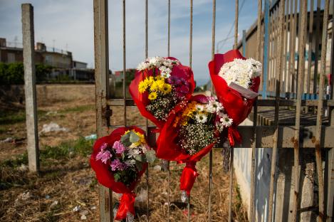 Memorial bouquets on a gate.