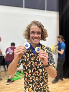 Person holding two medals.