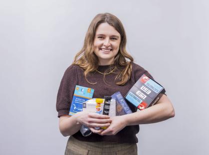 Woman holding various electrolyte drink products.