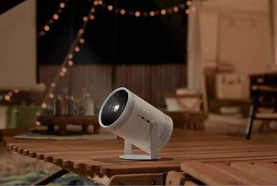 Portable projector projecting onto a wall outdoors.