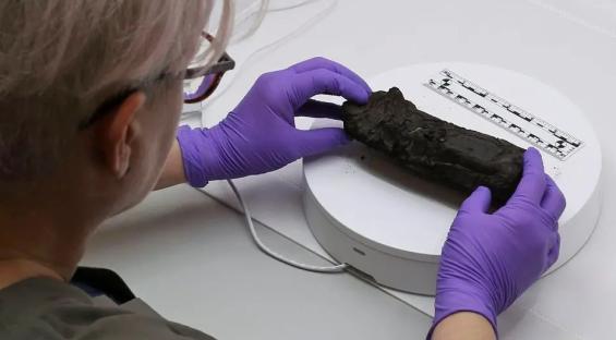 Burnt ancient scroll being examined.