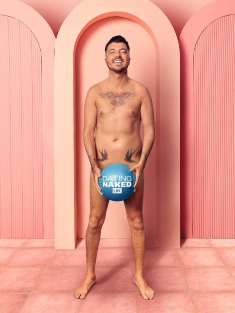 Luke Worley from Dating Naked UK holding a blue ball with the show's logo.