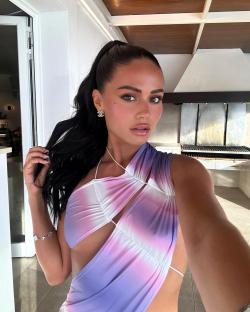 Woman in tie-dye dress taking a selfie.